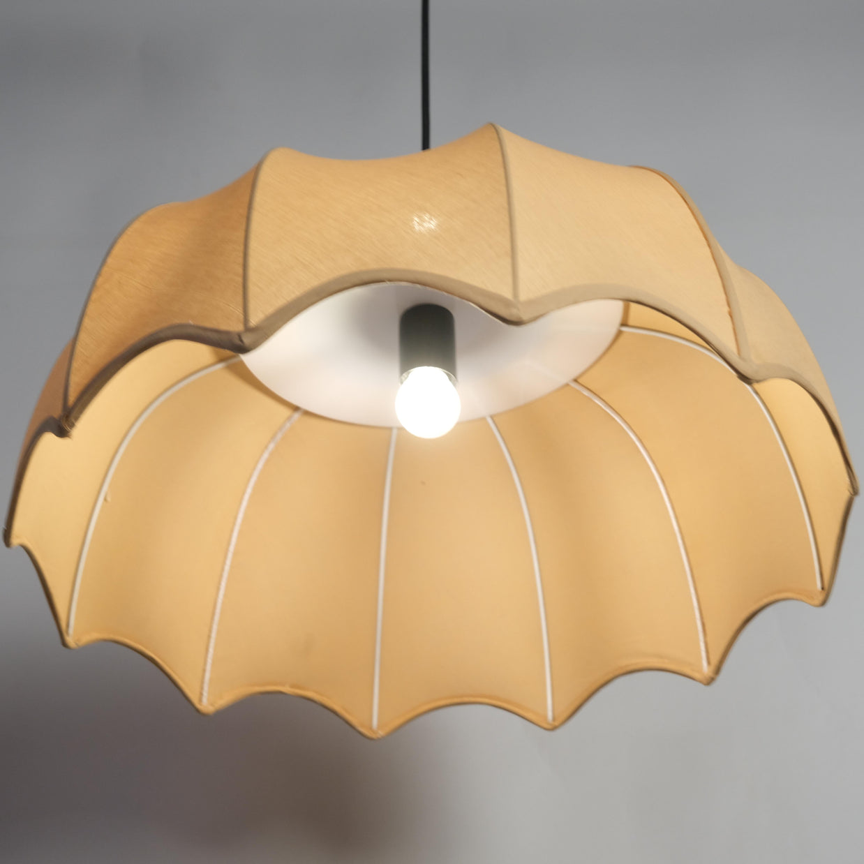 Adjustable cord fabric pendant light with a beige shade, ideal for versatile interior décor needs