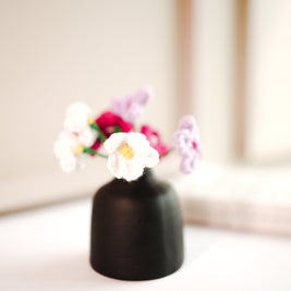 black bud vase with mini crochet daisies - https://artecasa.in/