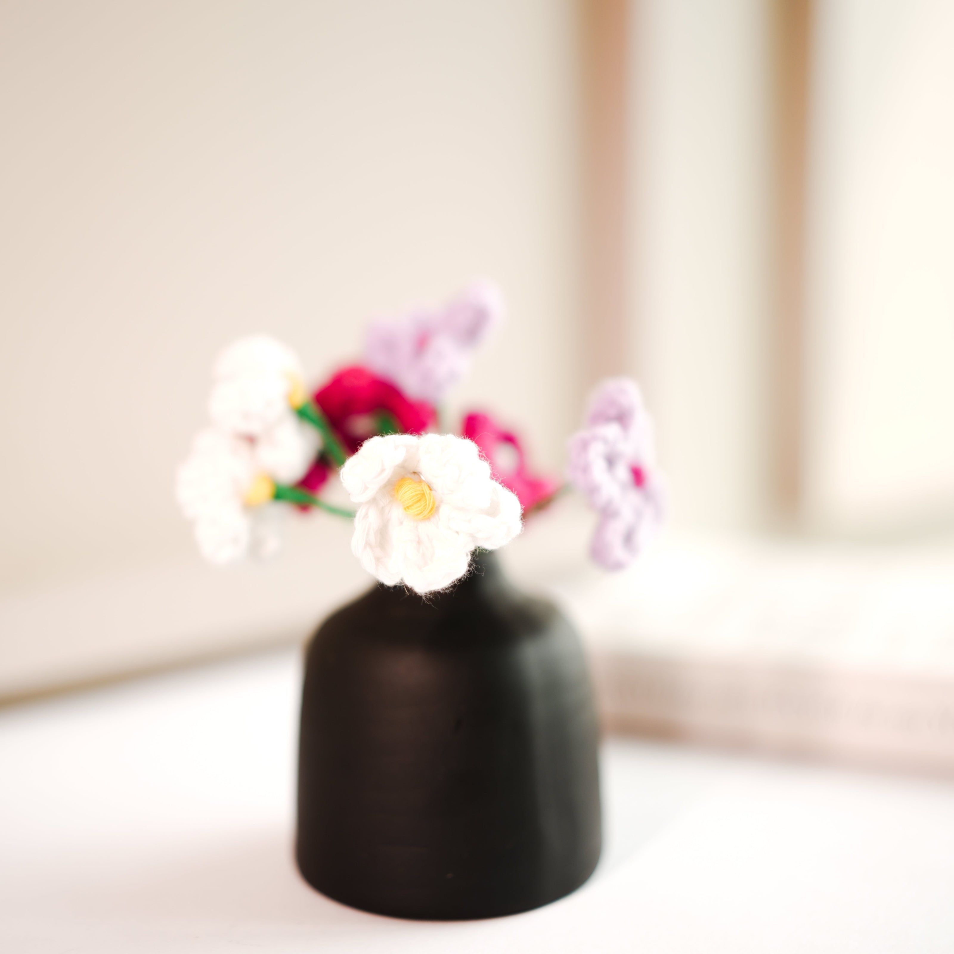 black bud vase with mini crochet daisies - https://artecasa.in/