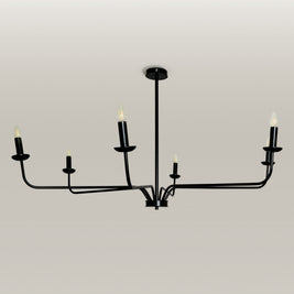 Candlelight Elegance Chandelier with sleek black metal arms and candle flame light bulbs, hanging in a modern living room.