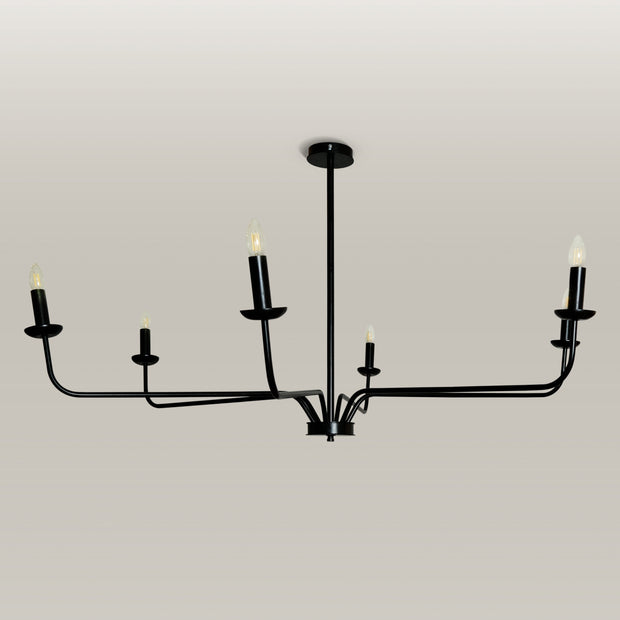 Candlelight Elegance Chandelier with sleek black metal arms and candle flame light bulbs, hanging in a modern living room.