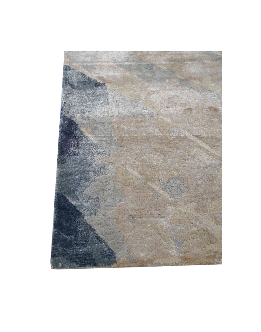 E V O K E luxury handmade rug by Cherom in muted blues and soft greys, crafted from New Zealand wool.