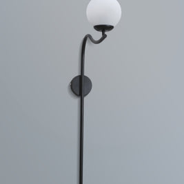 Elegant arched wall lamp featuring a black metal frame and a soft-glow white lampshade, enhancing a stylish interior.