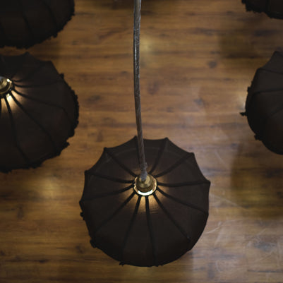 Elegant chandelier adorned with ornate glass designs, spreading soft light across a large ballroom.