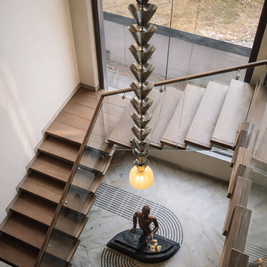 Modern staircase with a unique pendant light fixture and sculpture in a contemporary interior.