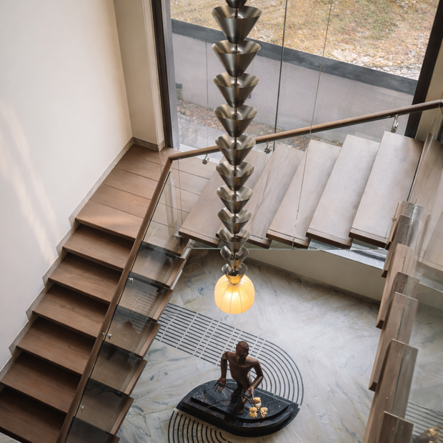 Modern staircase with a unique pendant light fixture and sculpture in a contemporary interior.