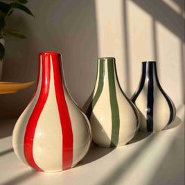 Three ceramic vases with striped patterns on a light background