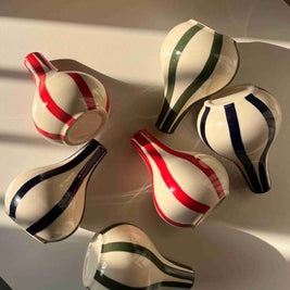 Set of ceramic vases with striped patterns on a white surface