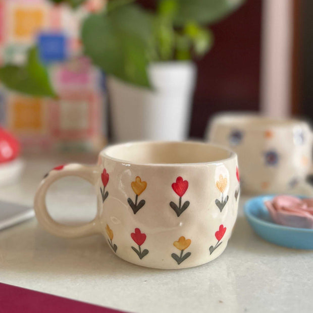 red and yellow flowers on a ceramic cup