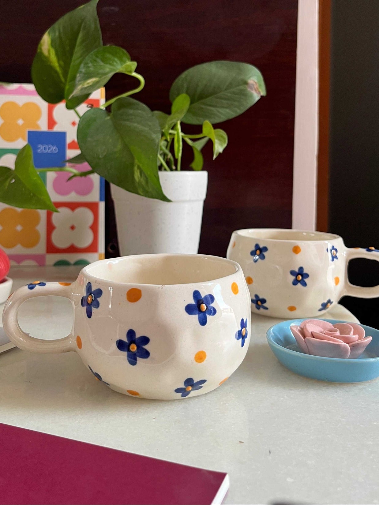 blue flowers with yellow 3D dot in the middle on a abstract white cramic cup