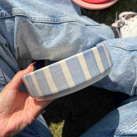 Person holding a striped blue and white bowl, elegant and modern cute aesthetic
