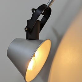 Industrial-style movable wall lamp with metal arm and clean geometry, mounted on a neutral wall.