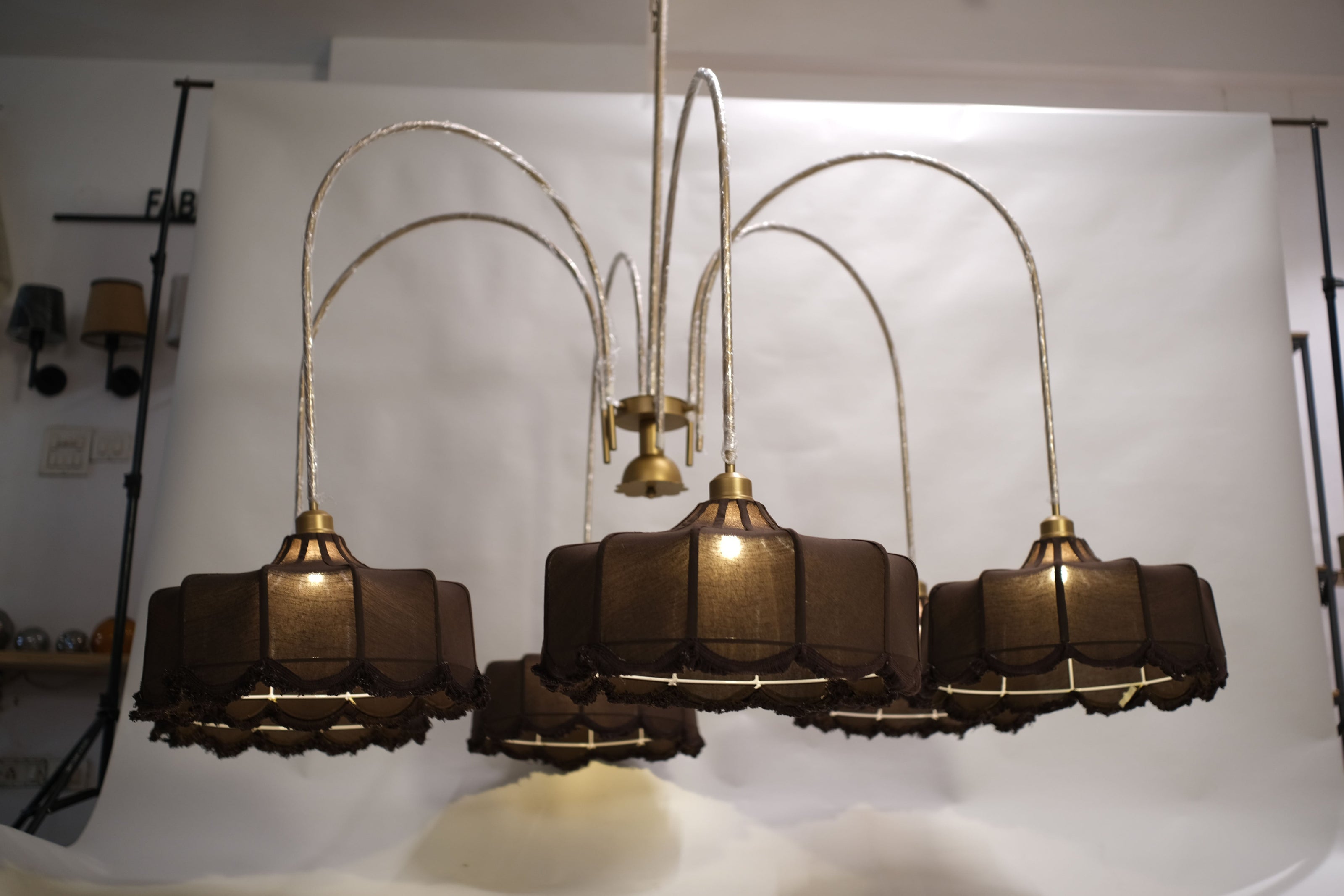 Luxurious modern chandelier featuring multiple tiers of warm glowing lights, suspended in a grand entryway.