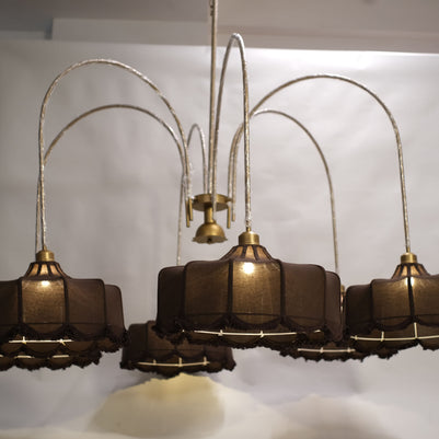 Luxurious modern chandelier featuring multiple tiers of warm glowing lights, suspended in a grand entryway.