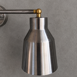Metallic wall light fixture on a gray background