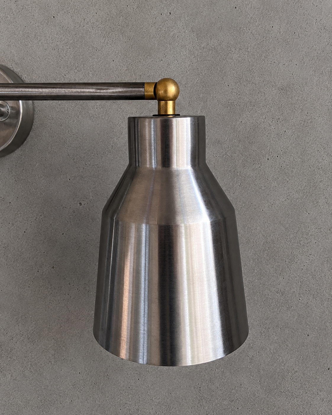 Metallic wall light fixture on a gray background