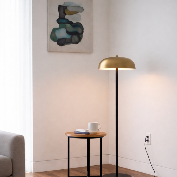 Modern living room with a gold floor lamp, side table, and abstract painting.