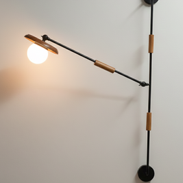 Modern wall-mounted light fixture with adjustable arm on a white wall