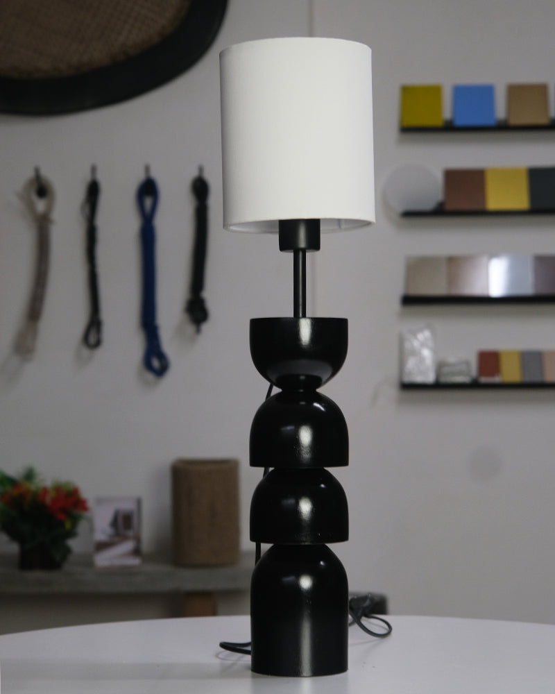 Sleek black and white table lamp with rounded segments and a modern minimalist design.