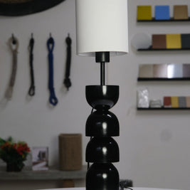 Sleek black and white table lamp with rounded segments and a modern minimalist design.