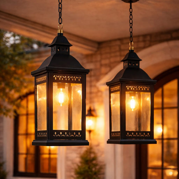 Two hanging outdoor lanterns with warm glow in front of a building entrance.