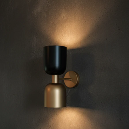 Wall-mounted light fixture with black and gold design on a dark wall.