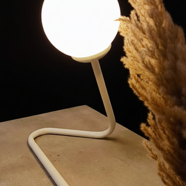 White lamp on a beige surface with a dark background