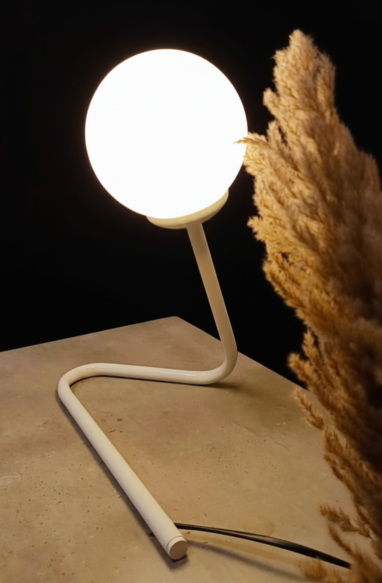 White lamp on a beige surface with a dark background