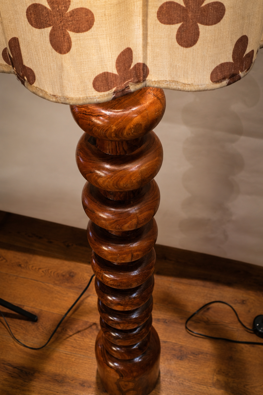 Wooden lamp with floral-patterned shade on a wooden floor.