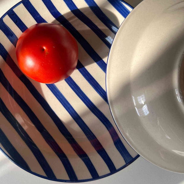 Hand-painted blue stripe pasta plate on cream ceramic base front and back