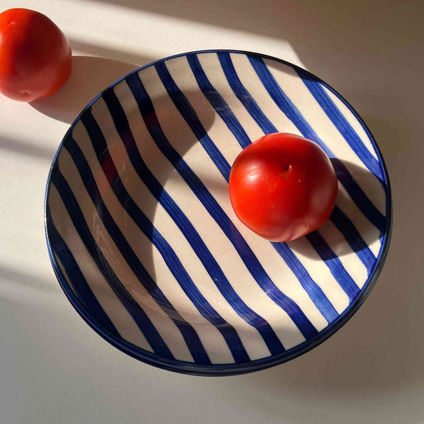 Ceramic pasta plate with bold blue stripes and glossy finish