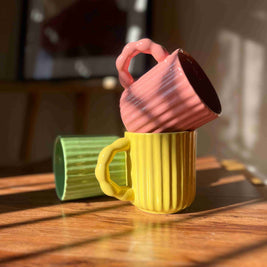Front view of the Chonky Sips set with pink, yellow, and green ceramic mugs.