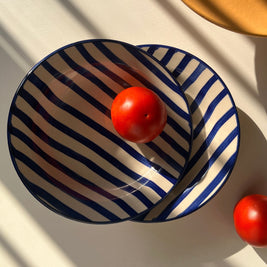 Wide shallow ceramic plate with deep blue hand-painted stripes