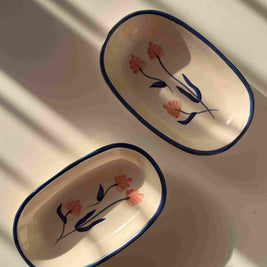 Two ceramic trays with floral designs on a white surface