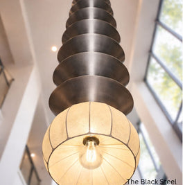 Modern pendant light with black steel design in a bright room