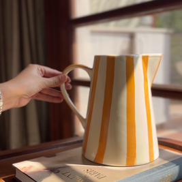 yellow jug vase out of the three colourful ceramic jug vases set styled as home decor.