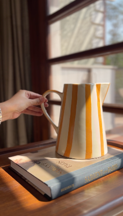 yellow jug vase out of the three colourful ceramic jug vases set styled as home decor.