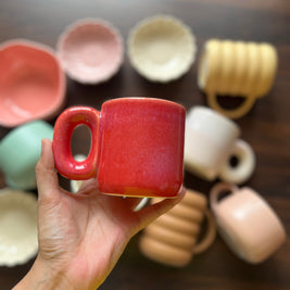 Red gradient ceramic mug with contemporary design held in hand perfect for coffee
