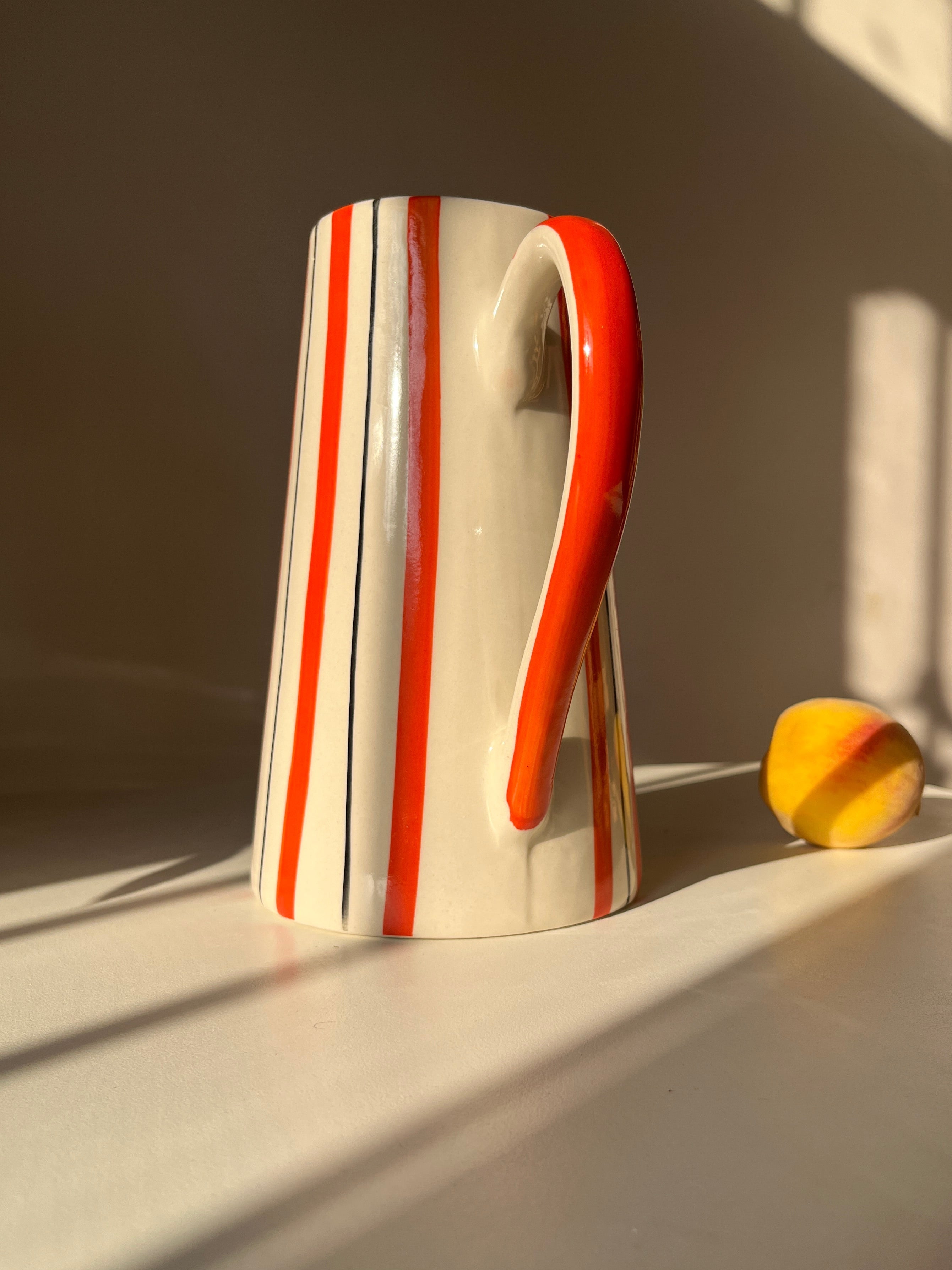 Marmalade ceramic jug vase styled in natural sunlight