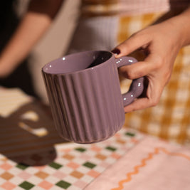 Person holding a modern ceramic coffee mug with ergonomic handle