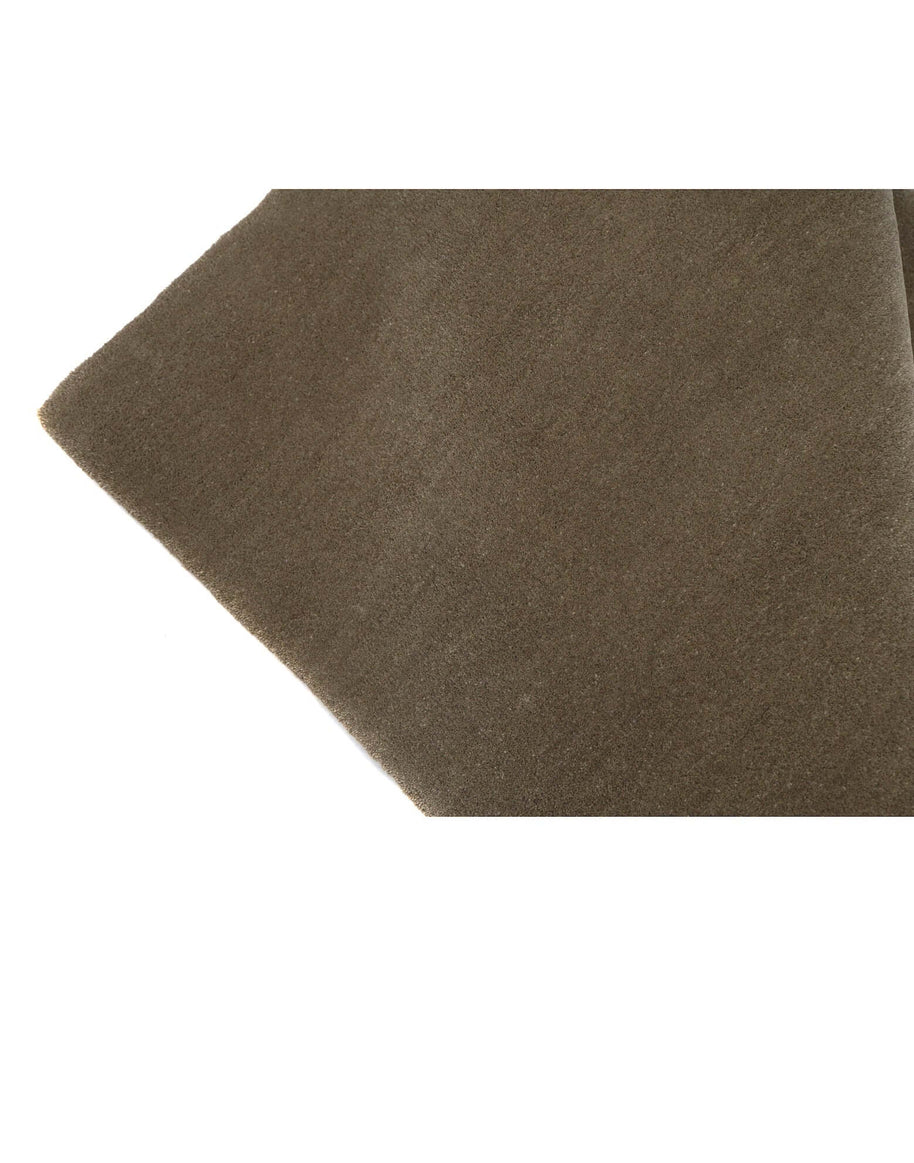 Close-up of I C O N - T R U F F L E rug in rich brown color, showcasing quality New Zealand wool and hand-serged edges.