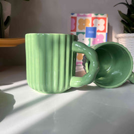 Close-up side view and top view of the ribbed ceramic texture and glossy green finish on the Kiwi Mug