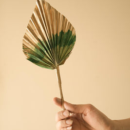 Luxury golden and green dual tone palm leaves arranged in a vase for elegant home decor setup
