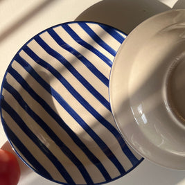 Ceramic serving plate with hand-painted blue striped design