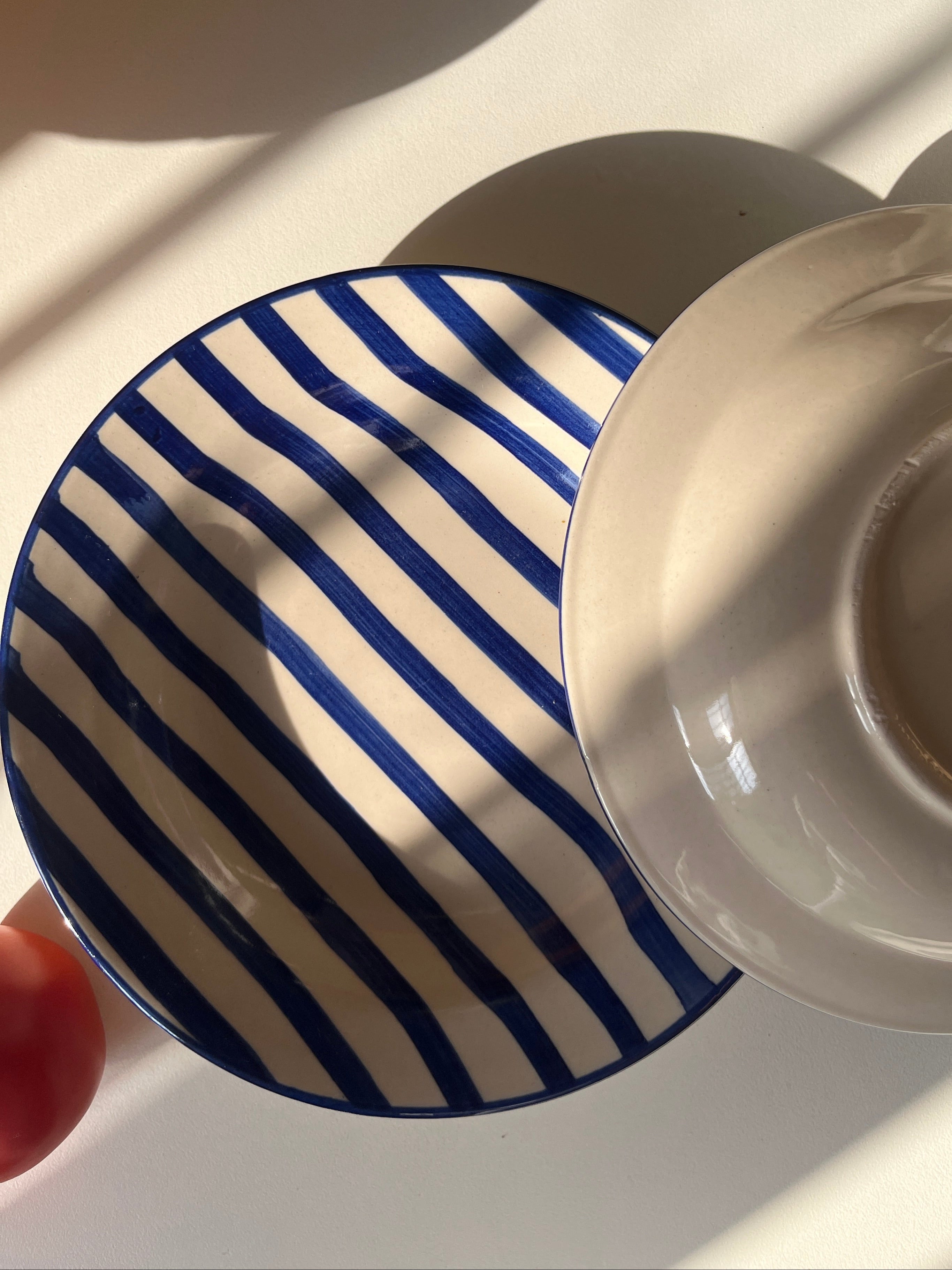 Ceramic serving plate with hand-painted blue striped design