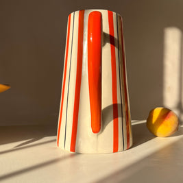 Tall ceramic jug vase with orange and fine dark line stripe detailing