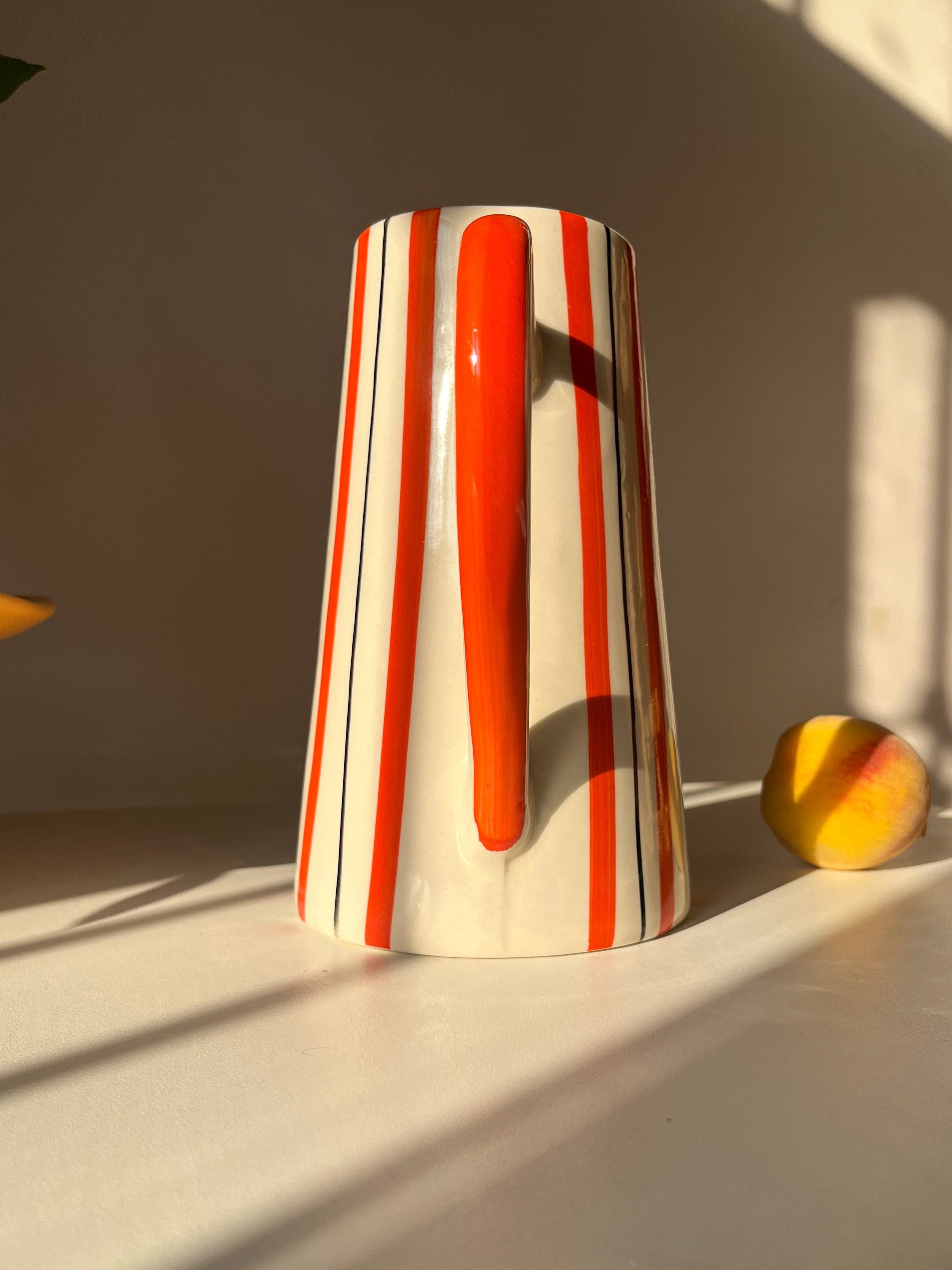 Tall ceramic jug vase with orange and fine dark line stripe detailing