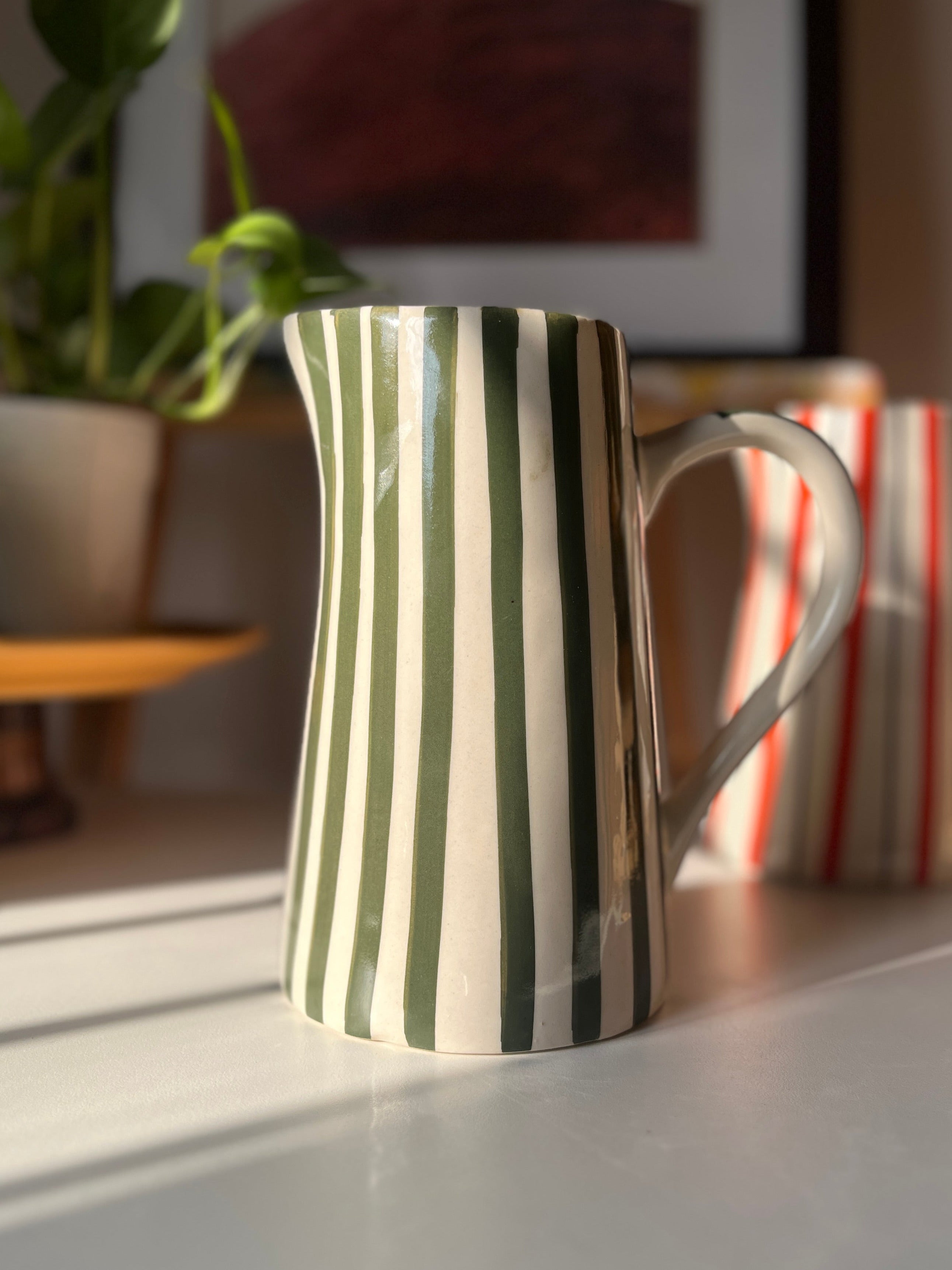 Glossy green striped ceramic vase for flowers and foliage
